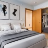 a bedroom with a nightstand, dresser and a closet