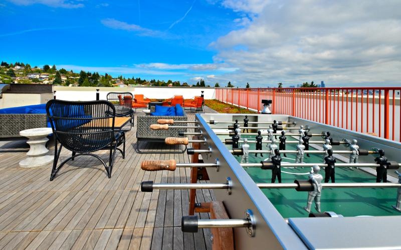 a rooftop area with chairs, tables and games